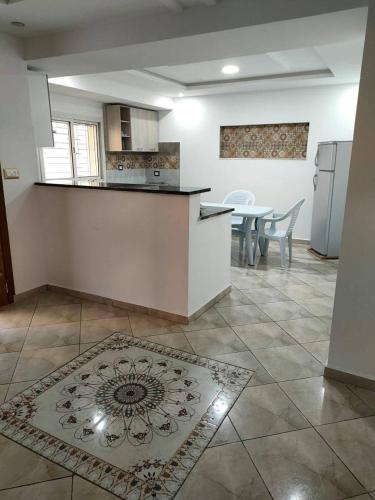 a kitchen and dining room with a table and refrigerator at Golden plage in Kelibia