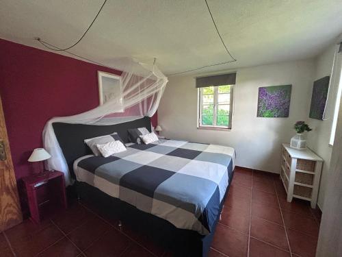 a bedroom with a bed with a black and white comforter at Quinta Inge in Paio Mendes