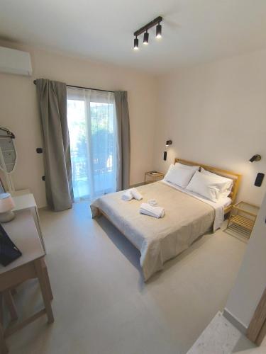 a bedroom with a large bed and a large window at Irene Studios in Nydri
