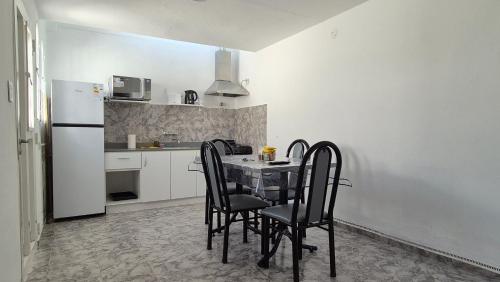 a kitchen with a table with chairs and a refrigerator at Colores Rio Cuarto in Río Cuarto