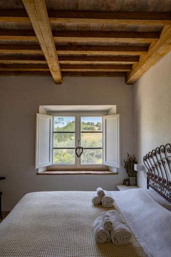 a bedroom with a bed and a window with towels on it at Agriturismo Poderino in Cinigiano