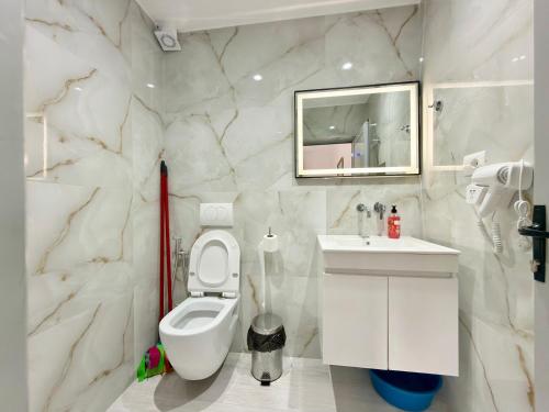 a white bathroom with a toilet and a sink at Villa Reshat Caca in Ksamil