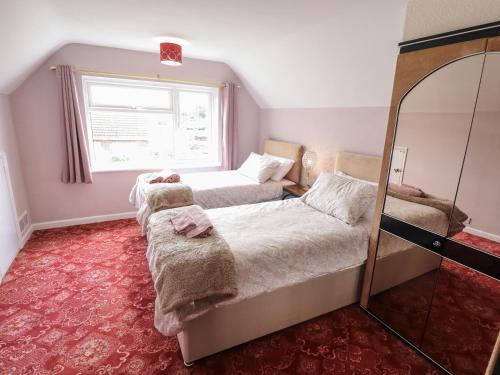 a bedroom with two beds and a mirror at Sandringham in Withernsea