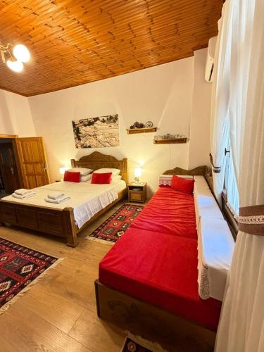 a bedroom with two beds with red pillows at Guesthouse Hoxha in Gjirokastër