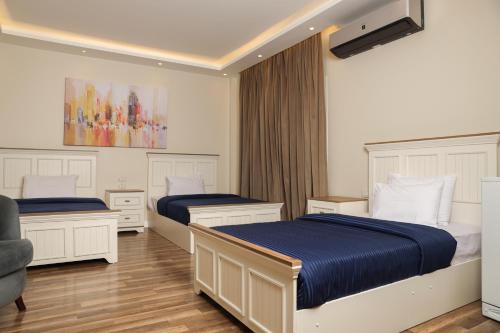 a bedroom with two beds and a chair at Munir’s residence in Cairo