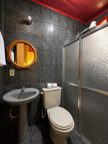 a bathroom with a toilet and a sink and a shower at Sea Blue Suites in Angra dos Reis