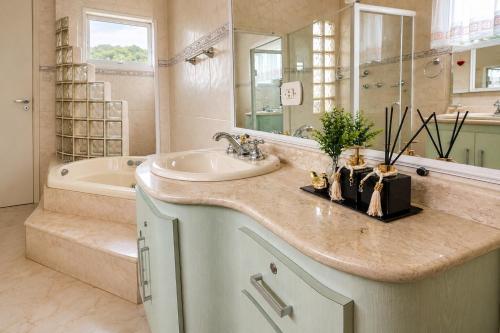 a bathroom with a sink and a tub at Pousada Casa Contos de Minas in Ubatuba