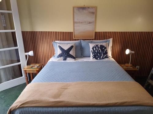 a bedroom with a bed with blue pillows and stars at Casa da Prainha - a 3min da areia - aproveite até o pôr do sol! in Arraial do Cabo
