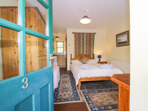 a bedroom with a bed and a blue door at Apartment 3 in North Lydbury