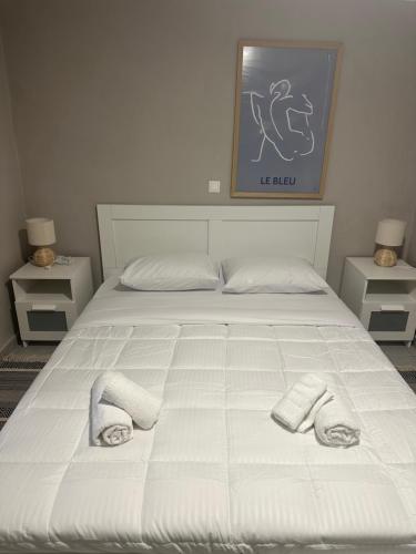 a large white bed with two towels on it at Nia The Yard in Nafpaktos