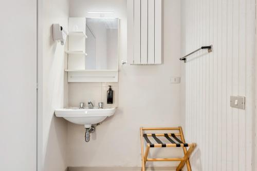 a white bathroom with a sink and a mirror at Hotel Sole in Marina di Massa