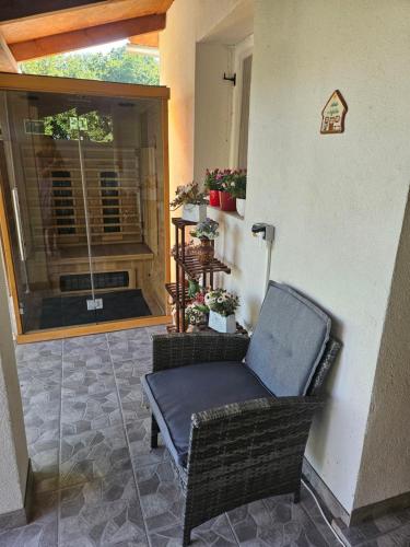 a wicker chair sitting on the porch of a house at Marina Cottage in Enying