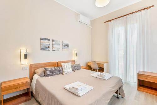 a white bedroom with a bed and a window at Hotel Sole in Marina di Massa