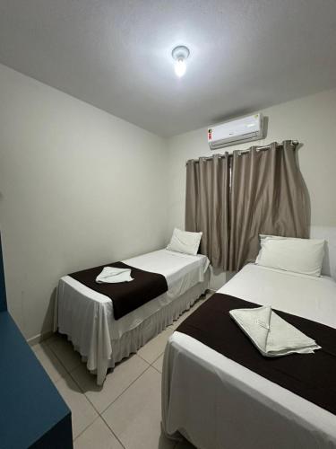 a room with two beds and a window with a heater at Pousada Caribe Brasileiro in Maragogi