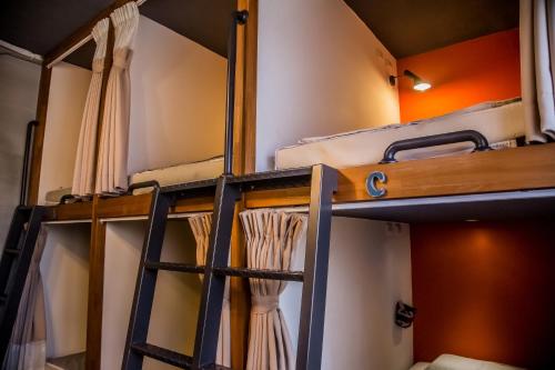 Knock Knock Hostel في كاوشيونغ: سرير بطابقين في غرفة مع ستائر