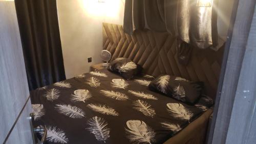 a bedroom with a bed with a black and white comforter at Sejeva in Ikorodu