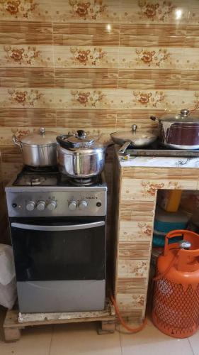 a kitchen with two pots and pans on a stove at Sejeva in Ikorodu