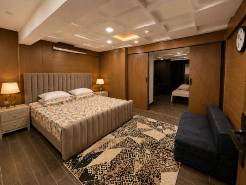a bedroom with a large bed and a couch at Cecil Apartments On Mall Road Murree in Murree