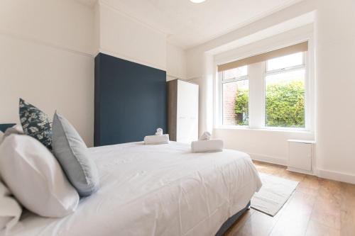 a white bedroom with a large white bed with pillows at Gordan Villas in Leigh