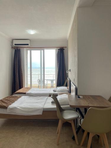 a bedroom with a bed and a table and a window at Sunrise Apartments and Studios in Star Dojran