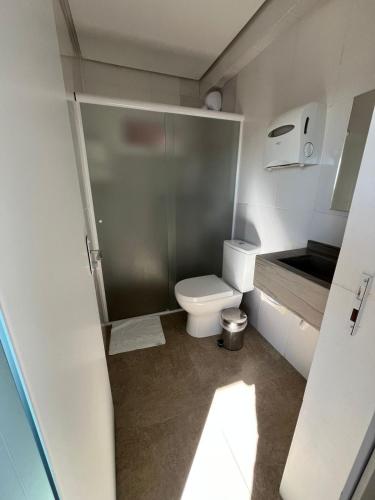a small bathroom with a toilet and a shower at Hotel Vanguarda Tapera in Tapera