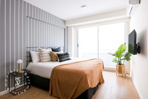 a bedroom with a bed and a large window at Top Rentals Palermo Chico in Buenos Aires