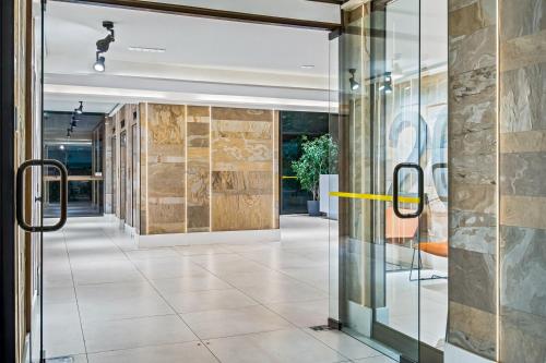 a hallway with a glass door with a yellow handle at Design Tech Comfort & Location in Santiago
