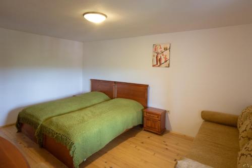 a small bedroom with a bed and a couch at Complex Rayuvski Han in Rayuvtsi