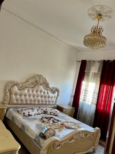 a bed in a bedroom with a chandelier at Dyrrah Rooms Central in Durrës