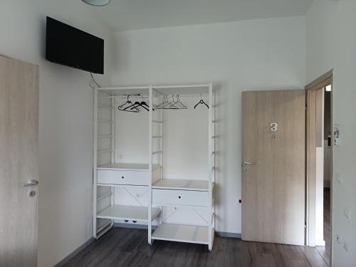 a closet with white shelves and a tv on a wall at B&B Villa AVE in Seriate