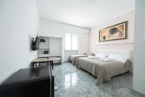 a bedroom with two beds and a flat screen tv at B&B Francy and sons in Modugno