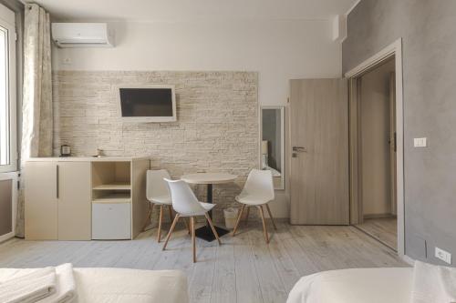 a living room with a table and chairs in a room at Trieste Centro Rooms-camere eleganti in pieno centro in Trieste