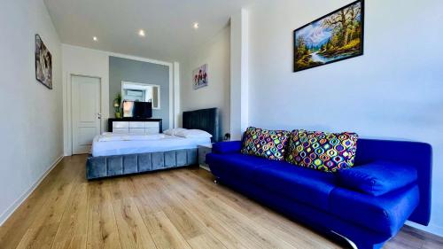 a living room with a blue couch and a bed at Marevista in Dramalj