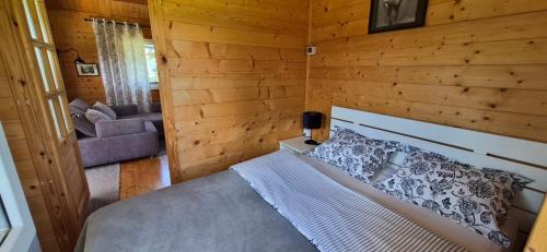 a bedroom with a bed in a room with wooden walls at Domki Pod Sudeckim Niebem in Duszniki Zdrój