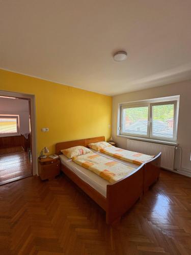 a bedroom with two beds and a yellow wall at Apartmaji Tomšič in Mojstrana