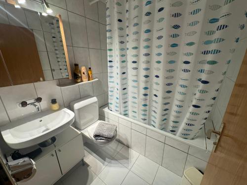 a bathroom with a sink and a shower curtain at Blue Ocean in Göschenen