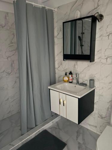 a bathroom with a sink and a shower curtain at Studio ANA Saturn 1 in Saturn
