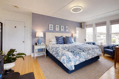 a bedroom with a blue and white bed and a chair at Blue Shutters Inn and Studios in Ogunquit
