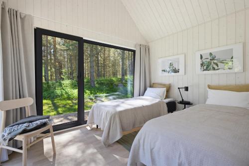 a bedroom with two beds and a large window at Kasispea Meremaja in Kasispea