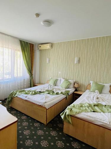 a hotel room with two beds and a window at Hotel Angely in Eforie Nord