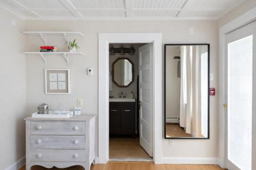 a bathroom with a mirror and a dresser at Blue Shutters Inn and Studios in Ogunquit