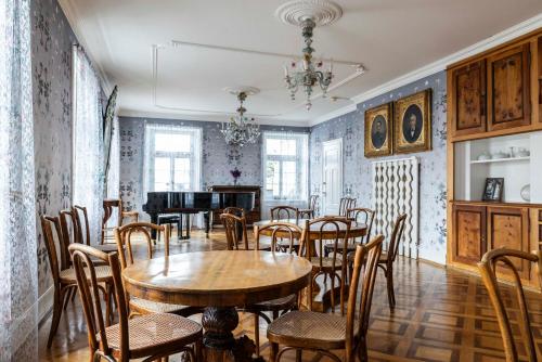 a dining room with a table and chairs and a piano at Hotel Pianta in Savognin