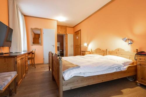 a bedroom with a large bed with white sheets at Hotel Pianta in Savognin