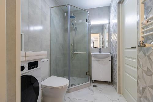 a bathroom with a shower and a toilet and a sink at Stylish 2BR Apartment in Yerevan in Yerevan