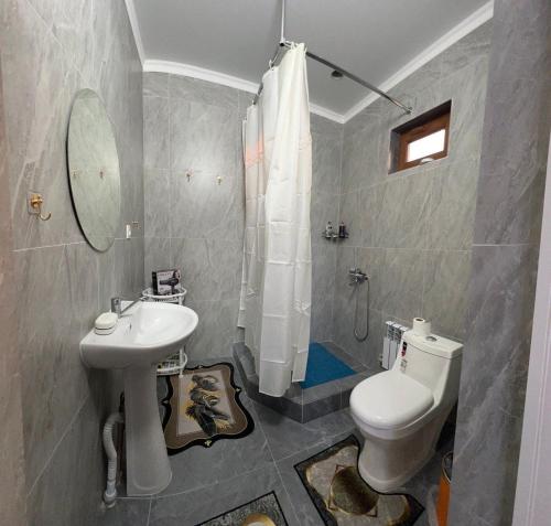 a bathroom with a white toilet and a sink at Kapshagay Lake in Kapchagay