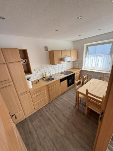 a kitchen with wooden cabinets and a table and a dining room at Das kleine Zuhause 1 in Bad Driburg
