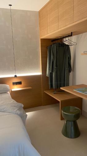 a bedroom with a bed and a desk and a green stool at Acouga in Miñortos