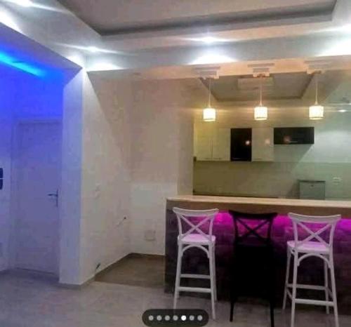 a room with a bar with two pink stools at Residence Dorra in Monastir
