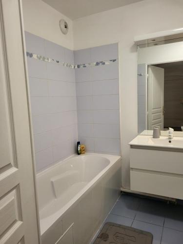 a white bathroom with a tub and a sink at 1 chambre double privée et securisée dans un appart avec espace partagé in Saint-Denis