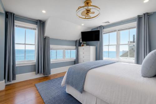 a bedroom with windows and a bed with a blue rug at Luxury York Oceanfront Nubble Views in York